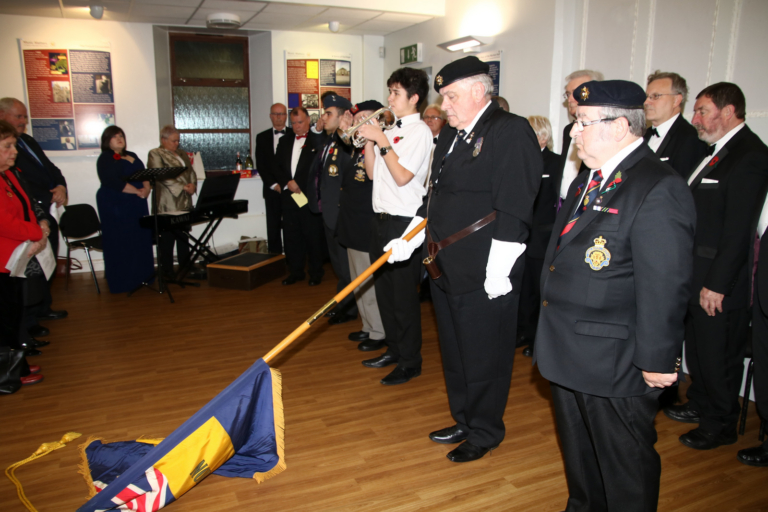 Emanual Williams playing "The Last Post" while the Standard of the Royal British Legion is lowered.